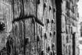 Shallow, black and white, high contrast view of a medieval wooden door at the entrance to an old castle. Royalty Free Stock Photo