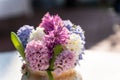 Shallow depth of field on a bouquet of hyacinths of different colors in a porcelain vase on the table, selective focus