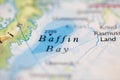 Shallow depth of field focus on geographical map location of Baffin Bay off coast of Greenland on atlas