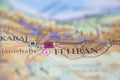 Shallow depth of field focus on geographical map location of Tehran city Iran Asia continent on atlas