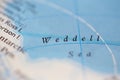 Shallow depth of field focus on geographical map location of Weddell Sea off coast of Antarctica on atlas