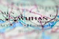 Shallow depth of field focus on geographical map location of Wuhan city China Asia continent on atlas
