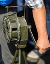 Shallow depth of field image with a man handling a vintage hand crank air raid siren