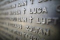 Shallow depth of field selective focus details with names of people who died in the Romanian Revolution from 1989 on a monument