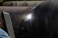 Shallow depth of field selective focus details with a professional welder welding an industrial metallic pipeline Royalty Free Stock Photo