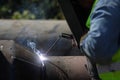 Shallow depth of field selective focus details with a professional welder welding an industrial metallic pipeline Royalty Free Stock Photo