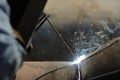 Shallow depth of field selective focus details with a professional welder welding an industrial metallic pipeline Royalty Free Stock Photo