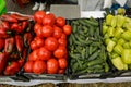 Shallow depth of field selective focus details with red and green peppers, tomatoes and cucumbers in an european farmers market Royalty Free Stock Photo