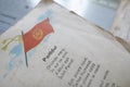 Shallow depth of field selective focus details with a Romanian Communist Party flag and nationalistic poem in an old children`s