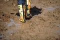 Shallow depth of field selective focus image with colorful rubber boots in very wet and deep mud Royalty Free Stock Photo