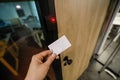 Shallow depth of field selective focus image with the hand of a man holding an access card inside an office building