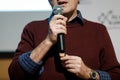 Shallow depth of field selective focus image with the hands of a man holding a microphone and delivering a speech