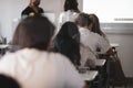 Shallow depth of field selective focus image with high school pupils wearing masks and with separators during the Covid-19