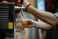 Shallow depth of field selective focus image with a man pouring craft beer from a dispenser into a plastic glass Royalty Free Stock Photo