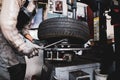 Shallow depth of field selective focus image with a mechanic changing the regular summer tyres of a car with winter tyres in a