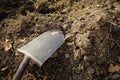 Shallow depth of field selective focus image with a metal shovel on a piece of agricultural plowed land