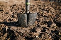 Shallow depth of field selective focus image with a metal shovel on a piece of agricultural plowed land