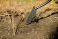 Shallow depth of field selective focus image with a metal shovel on a piece of agricultural plowed land