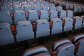 Shallow depth of field selective focus image with numbered chairs inside a theatre/cinema.