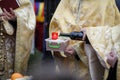 Shallow depth of field selective focus image with an orthodox priest pouring wine on a funeral cake during a ceremony