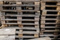 Shallow depth of field selective focus image with a pile of wooden EPAL Euro pallets stacked outdoors Royalty Free Stock Photo