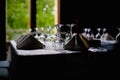 Shallow depth of field selective focus image with a restaurant table ready to receive customers. Empty glasses and tableware