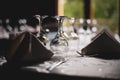 Shallow depth of field selective focus image with a restaurant table ready to receive customers. Empty glasses and tableware
