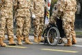 Shallow depth of field selective focus image with Romanian army veteran soldiers, of which one is injured and disabled, sitting