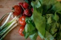 Shallow depth of field selective focus image with salad ingredients spring onions on a wooden cutter - spring onions, tomatoes,