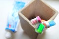 Shallow DOF shot of three toothbrushes and toothpaste in a clay tumbler in the morning light Royalty Free Stock Photo