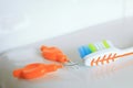 Shallow DOF shot of a toothbrush and interdental brushes on a shiny surface