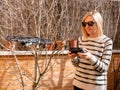 Shallow focus of a Caucasian woman piloting a drone at a backyard