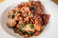 Shallow focus on chopped sausage and bacon in a dish with also includes spinach, onions, lentils and sun-dried tomatoes Royalty Free Stock Photo