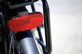 Shallow focus close up of a the red rear reflector on a bicycle