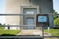 Shallow focus of a water supply company gated entrance, showing part of the large concrete water tower.