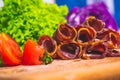 Shallow focus closeup of a pile of cold-cut meat with sliced tomatoes on the side Royalty Free Stock Photo