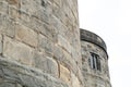 Shallow focus of a distant, medieval tower and gothic style windows.