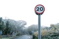 Shallow focus of a frozen 20 Mph speed limit sign seen at the edge rural community.