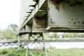 Shallow focus, high contrast of a weathered metal conveyor system, spanning a river.