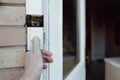 Shallow focus of a homeowner seen testing a newly installed WiFi smart doorbell.