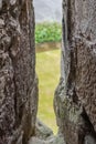 Shallow focus of the interior of a very old, medieval building looking out through a defensive slot.