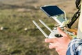 Shallow focus of male hands holding a remote controller of a drone on blurred background of a field Royalty Free Stock Photo