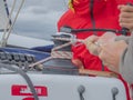 Shallow focus of men maneuvering a sheet winch while sailing at sea