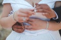 Shallow focus of a newly married couple embracing and putting rings on their fingers in a park