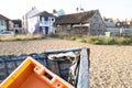 Shallow focus of an orange, plastic crate seen discarded in a on wooden boat. Royalty Free Stock Photo