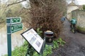 Shallow focus of public footpath signs adjacent to a near flooded river