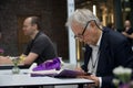 Shallow focus of Richard Dawkins reading a book at a conference about Dissent in Koln, Germany