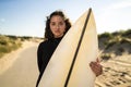 Shallow focus shot of an attractive female holding a surfboard in the middle of the road in Spain