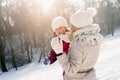 Shallow focus shot of a caucasian mother playing with her daughter on a snowy day