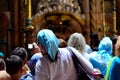 Shallow focus shot of a female standing in a crowded church in Jerusalem, Israel
